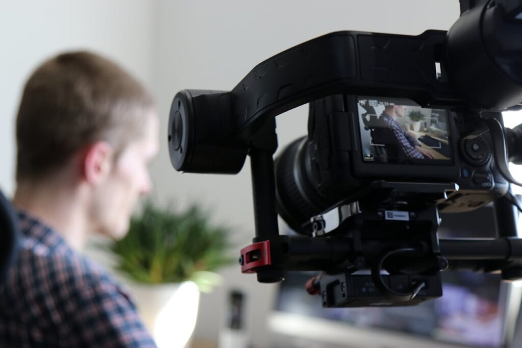 pexels photo 1046151 Close-up of camera filming a man in an indoor setting, highlighting professional video production